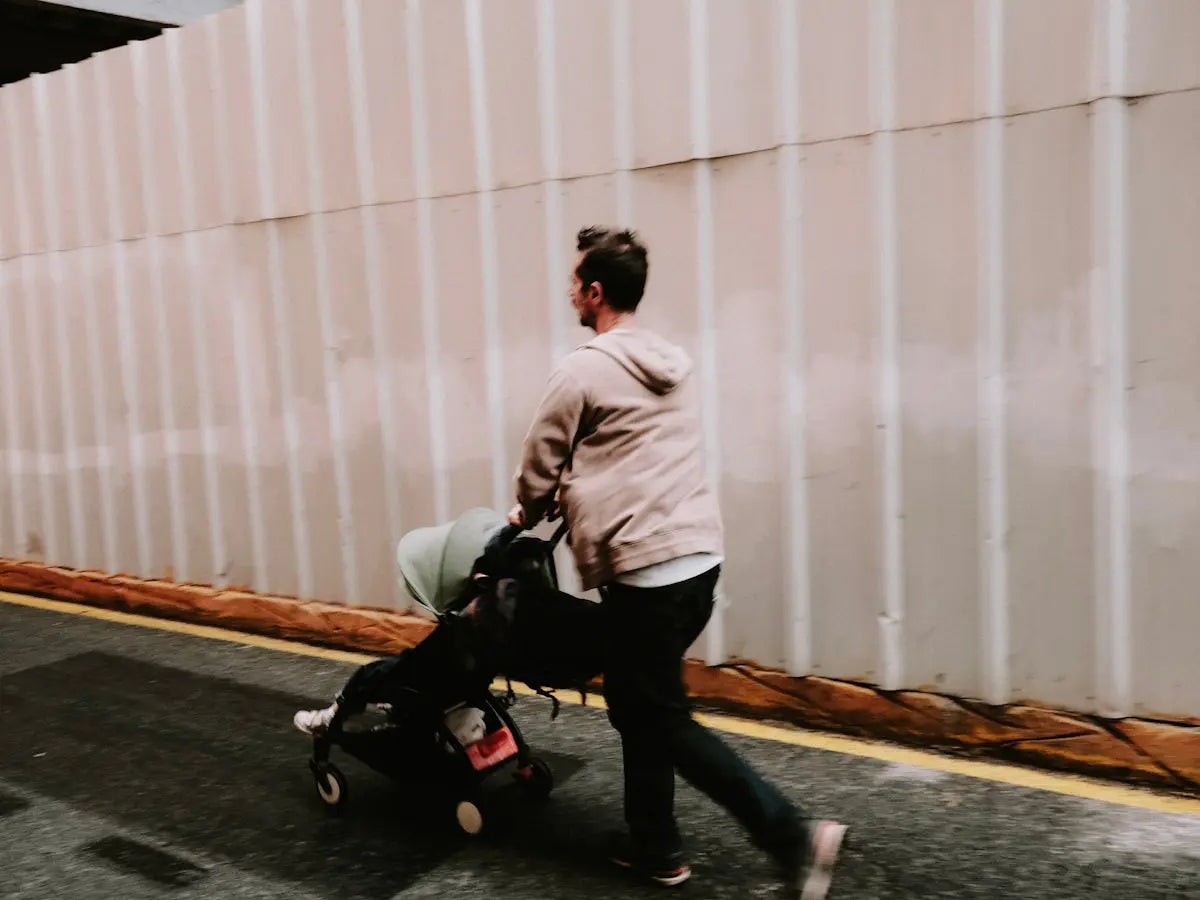 a man pulling a baby carriage down a street