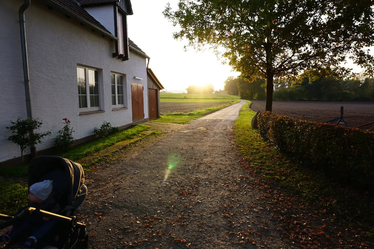 Gravel path leads to a house at sunset