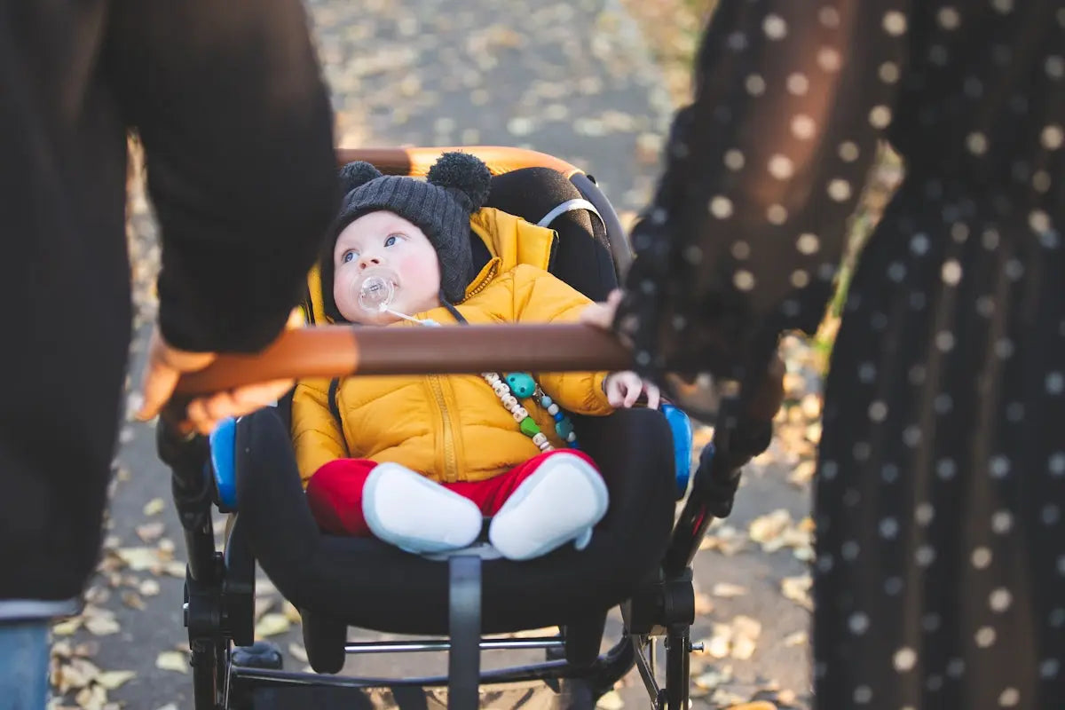 Parents push a baby in a stroller.